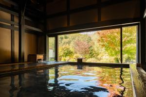 a large swimming pool with a large window in a building at Hotel Sierra Resort Hakuba in Hakuba