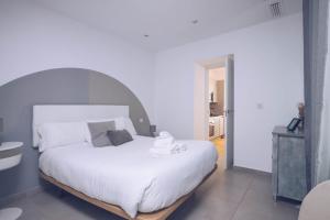 a bedroom with a large white bed in a room at Eclectic 2BR with shared terrace perfect getaway in Gibraltar