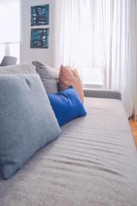 a couch with blue pillows on top of it at Eclectic 2BR with shared terrace perfect getaway in Gibraltar +20 photos