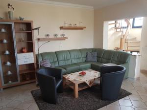 a living room with a green couch and a table at Gruppenunterkunft mit Pool in Ballenstedt in Ballenstedt +30 photos