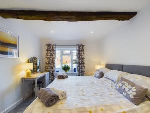 a bedroom with a large bed and a desk at Woodman's Cottage, Penrith in Penrith