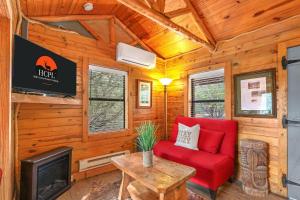 a living room with a red couch and a tv at Cozy Cabin in Wimberley