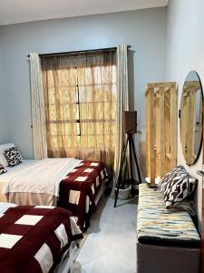a bedroom with two beds and a window at Sinana Escapes - Arusha in Arusha