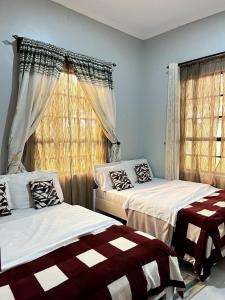 a bedroom with two beds and a window at Sinana Escapes - Arusha in Arusha
