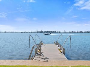 un muelle en un lago con un barco en el agua en Waterview Place Holiday House, en Yarrawonga