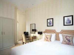 a bedroom with a bed and a desk with a computer at Hotel Xenia, Autograph Collection in London