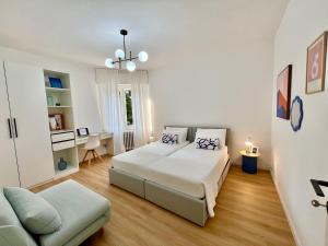 a white bedroom with a bed and a couch at 3 Kappa in Calolziocorte