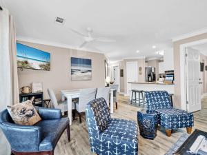 a living room with chairs and a dining room at Beachside Villas 122- Sun for the Roses in Santa Rosa Beach