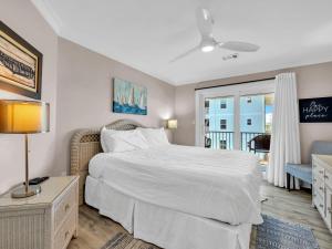 a bedroom with a large white bed and a window at Beachside Villas 122- Sun for the Roses in Santa Rosa Beach