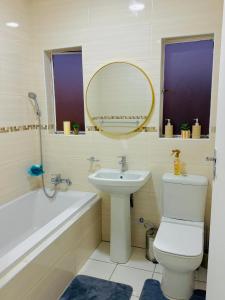 a bathroom with a sink and a toilet and a mirror at Beautiful Luxury Apartment in Johannesburg