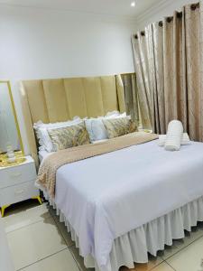 a bedroom with a large bed and a mirror at Beautiful Luxury Apartment in Johannesburg