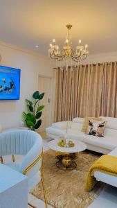 a living room with white furniture and a chandelier at Beautiful Luxury Apartment in Johannesburg