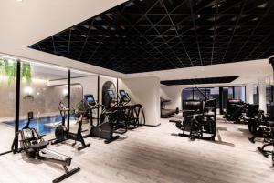 un gimnasio con cintas de correr y máquinas elípticas en Luxe Apartment in M1 with Pool, Gym & Spa, en Mánchester