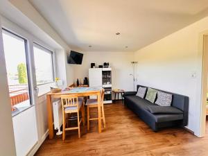 a living room with a black couch and a table at Appartement Traunsteinblick in Altmünster