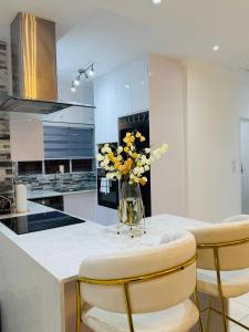 a kitchen with a table with yellow flowers in a vase at Beautiful Luxury Apartment in Johannesburg +16 photos
