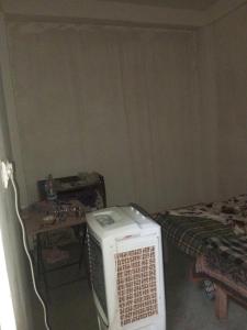 a room with a room with a bed and a microwave at Nirbhay home in Kānpur