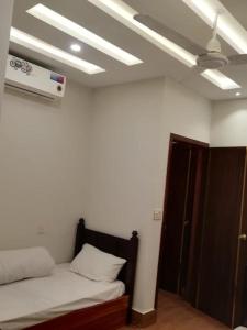 a bedroom with a bed and a ceiling fan at 8 Rawal Inn in Dargai