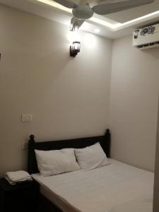 a bed in a room with a ceiling fan at 8 Rawal Inn in Dargai