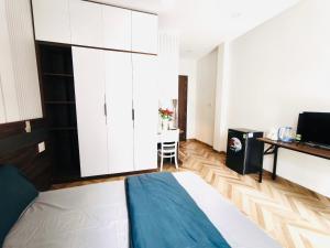 胡志明市Kim's studio的一间卧室，里面有一张床、一张桌子和一台电视。