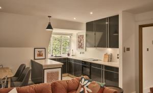 ein Wohnzimmer mit Couch und Küche in der Unterkunft The Flat - Waresley Park Estate 