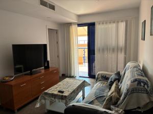 a living room with a couch and a tv at Apartamento de lujo, para relajarse en Mojácar in Mojácar