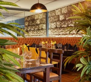 a dining room with a table and chairs and plants at Lydons Lodge Hotel in Cong