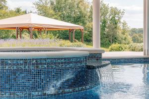 einen Pool mit einem Brunnen und einem Sonnenschirm in der Unterkunft The Flat - Waresley Park Estate 