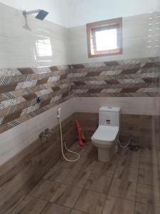 Un baño con inodoro y ventana. en Munnar Mountain view cottage, en Munnar