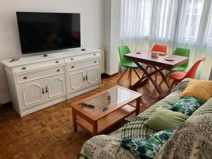 a living room with a couch and a television on a dresser at El COTO - VUT 6639 AS in Gijón