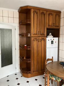 a kitchen with wooden cabinets and a white refrigerator at El COTO - VUT 6639 AS in Gijón +9 photos