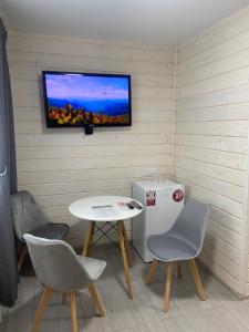a small room with a table and a tv on a wall at Yaremchuk lodge in Tyudov