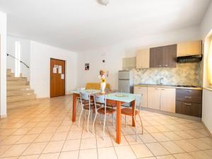 a kitchen and dining room with a table and chairs at Belvilla by OYO Conca degli Dei con giardino in Paestum