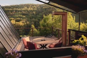 a patio with a table and chairs on a balcony at Glamp Ellsa in Mikulov v Krušných Horách