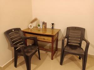 a wooden table and two chairs in a room at Deep Guest House in Arambol