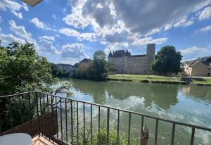 a view of a river with a building in the background at Vue imprenable in Nemours