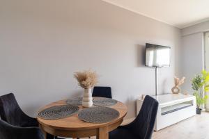 a dining room with a wooden table and black chairs at Apartament MOJA MŁYNOWA in Białystok