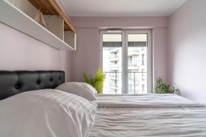 a white bedroom with a large bed with a window at Apartament MOJA MŁYNOWA in Białystok +11 photos