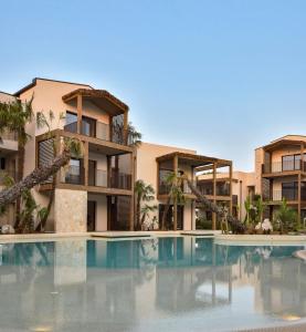 a swimming pool in front of some apartments at Caribe Sunset - Large 3 Bedrooms with Caribbean Pool in Lido di Jesolo