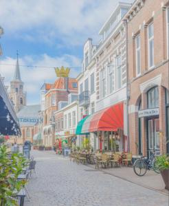 a city street with tables and chairs and buildings at Apartment by the Beach in Scheveningen +5 photos