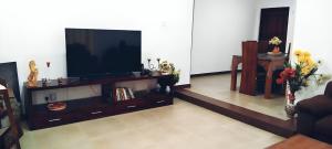 a living room with a flat screen tv on a entertainment center at Lotus Villa in Katunayake