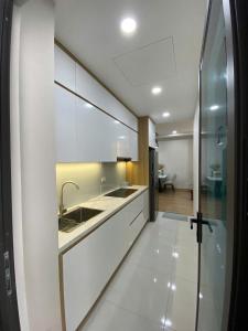 Una cocina con gabinetes blancos y un fregadero. en HomeStay Old Quarter Hai Phong, en Hai Phong