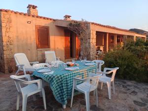 a table with white chairs and a blue and white table cloth at villetta costa paradiso in Costa Paradiso