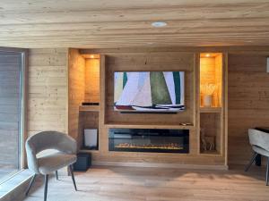 a living room with a fireplace and a tv at Appartement Nivalis - LES GETS, en plein centre et au pied des pistes in Les Gets