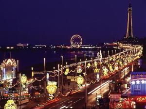 Una ciudad de noche con la torre Eiffel y los relojes en Palm Beach Hotel by the Sea, en Blackpool