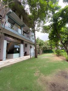 a building with a green lawn in front of it at Hotel regal garden in Faridabad