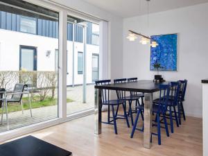 a dining room with a black table and blue chairs at 6 person holiday home in Væggerløse-By Traum in Marielyst