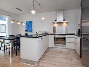 a kitchen with white cabinets and a table in it at 6 person holiday home in Væggerløse-By Traum in Marielyst