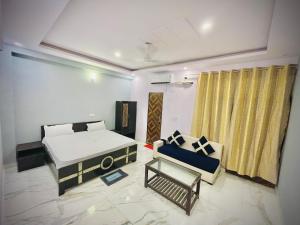a living room with a bed and a couch at Hotel regal garden in Faridabad