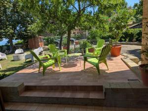 a group of green chairs and tables on a patio at Appartamento spazioso montone vista mare in Montone +17 photos
