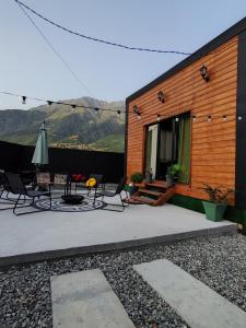 a patio with chairs and an umbrella and a building at Wooden house nica in Lagami +26 photos